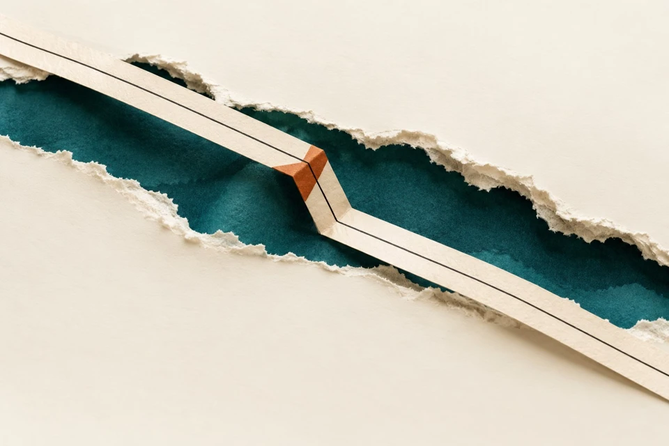 A rust-colored insert redirects a constructed paper bridge across a torn page.